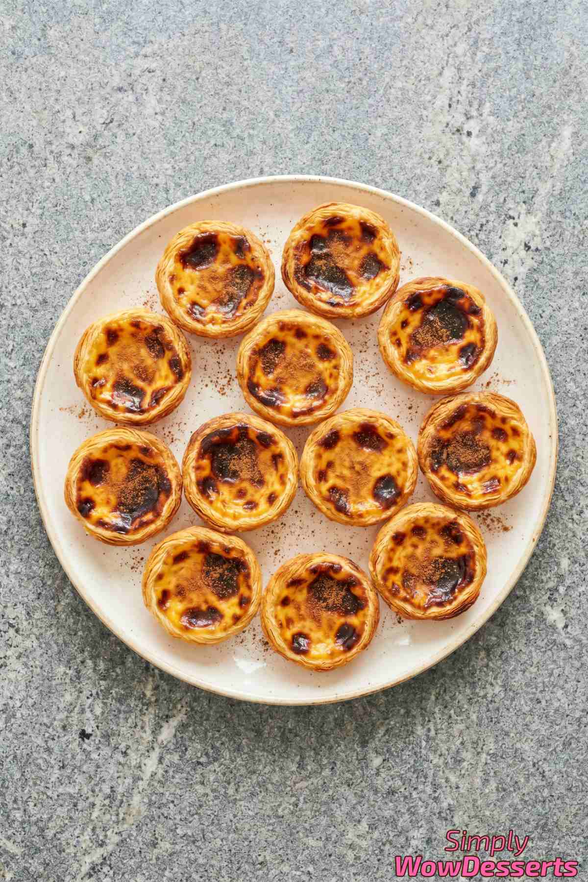 Charred-top Portuguese custard tarts dusted with cinnamon
